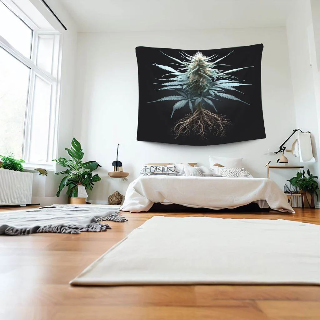 A large black tapestry with a green cannabis plant in the center hangs on the wall of a white bedroom with a window.